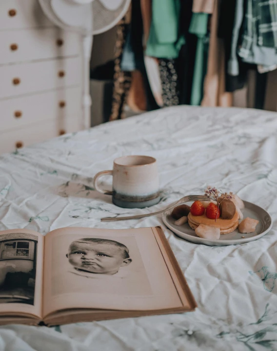 a cup of coffee and a book on a bed