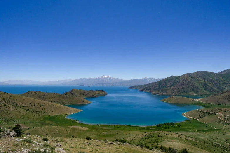 a scenic view of a mountain range and a lake in the background