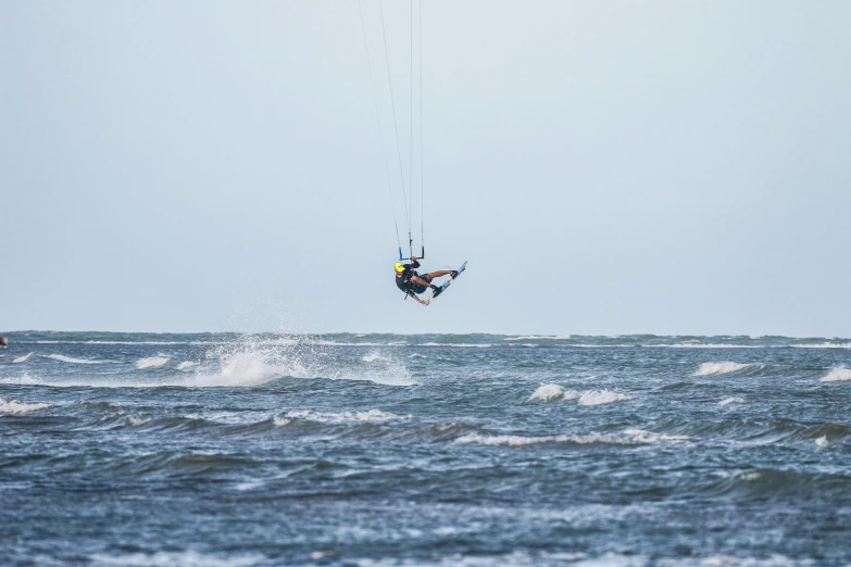 there is a man kiteboarding over a wave