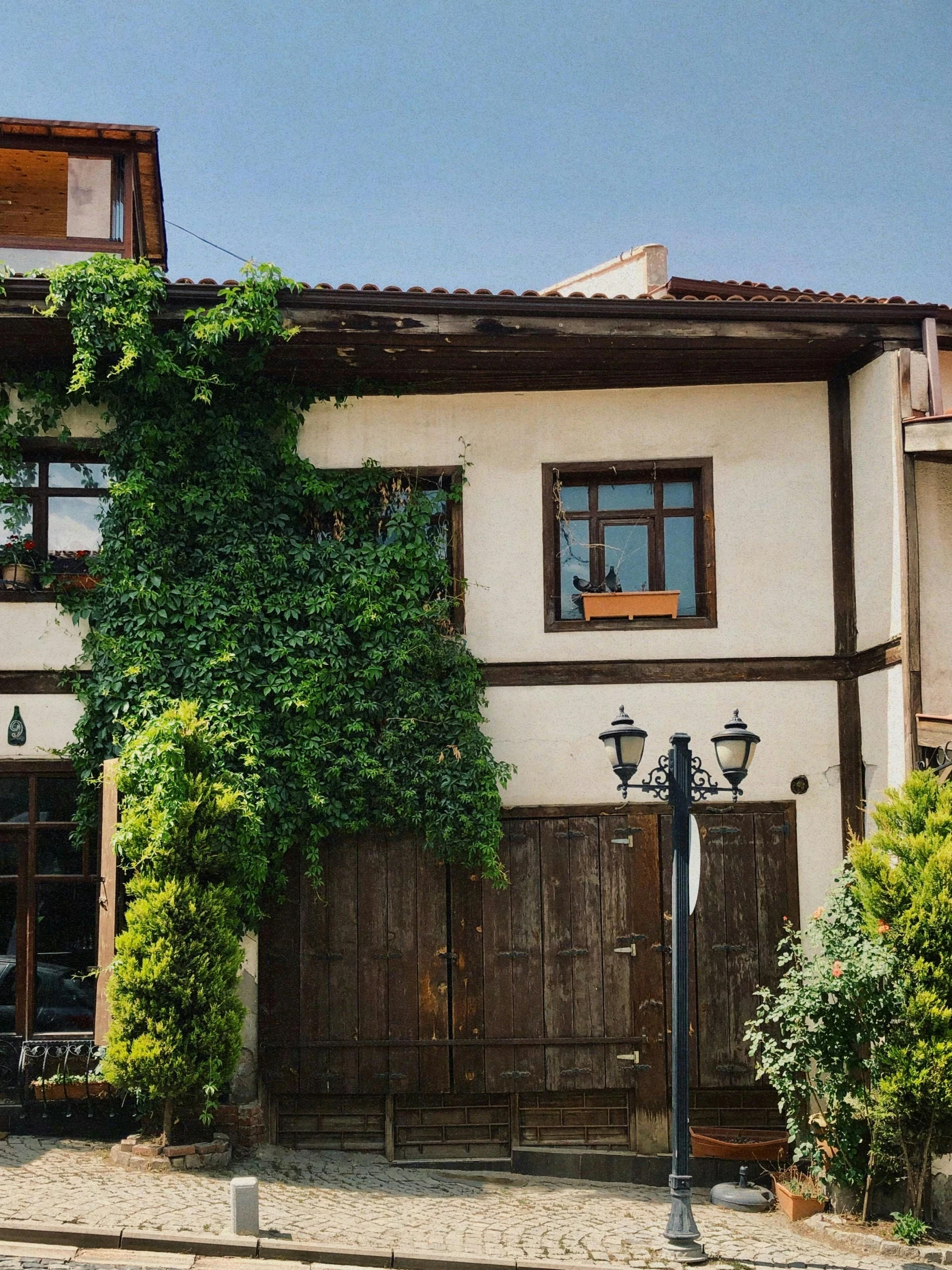 a home with ivy on the walls and garage door