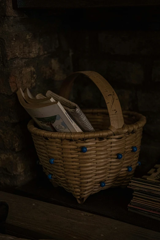 a basket with blue ons is sitting near a fireplace