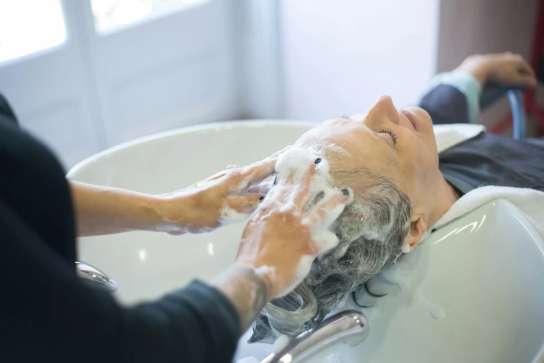 a man is getting his hair washed while having a shave