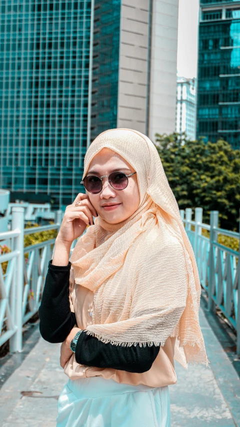 woman wearing a headscarf standing by a bridge