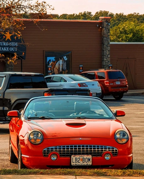 the red sports car is parked in front of the parking lot