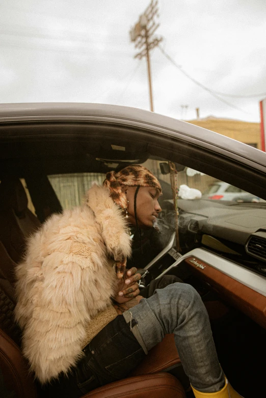 a woman in jeans sits inside of a car