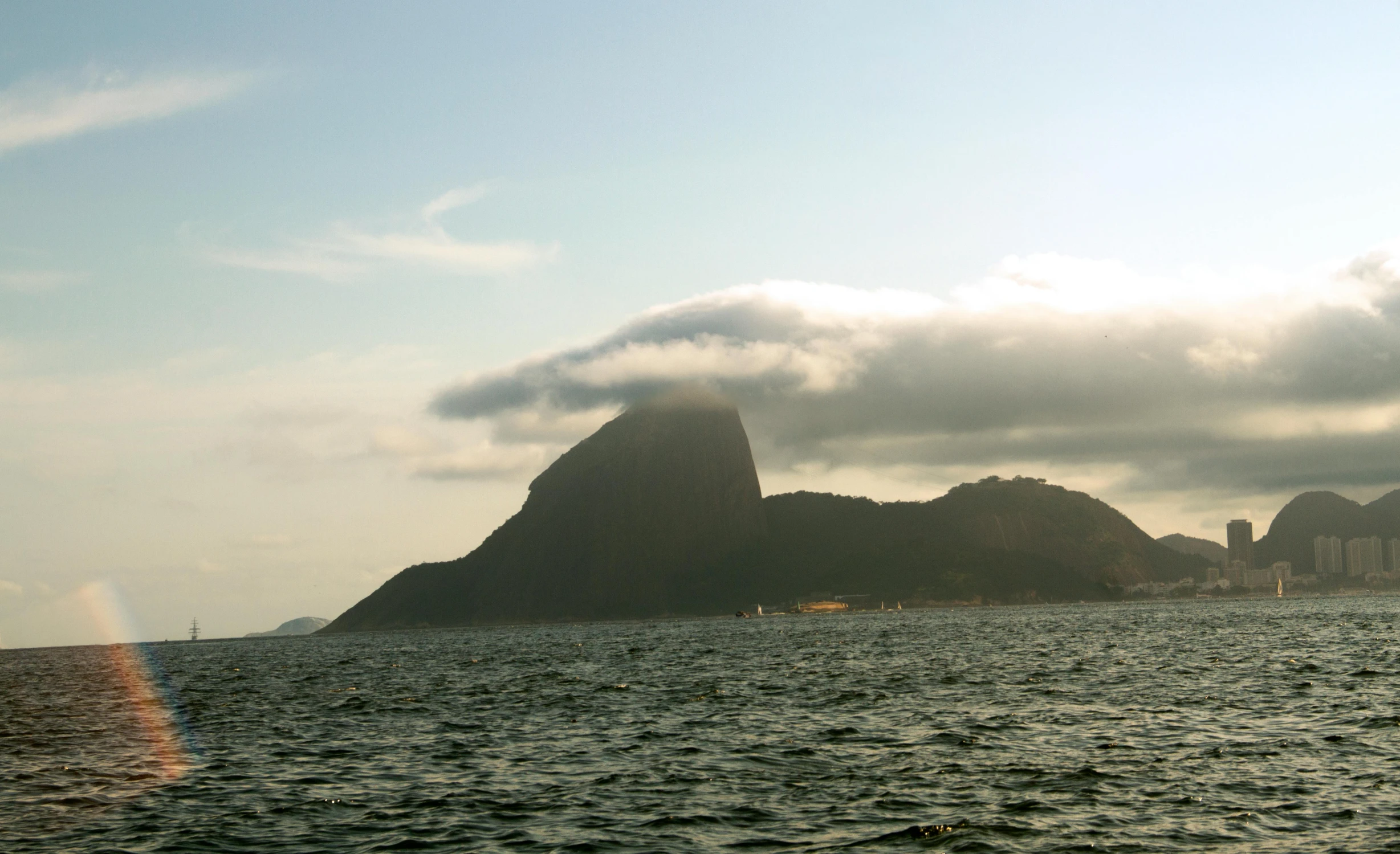 a mountain is in the background behind some dark rocks