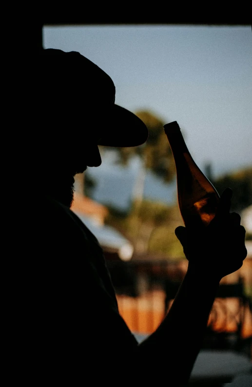 a person holding a bottle of wine by their side