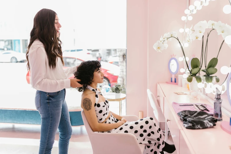 a woman is having her hair done by a lady