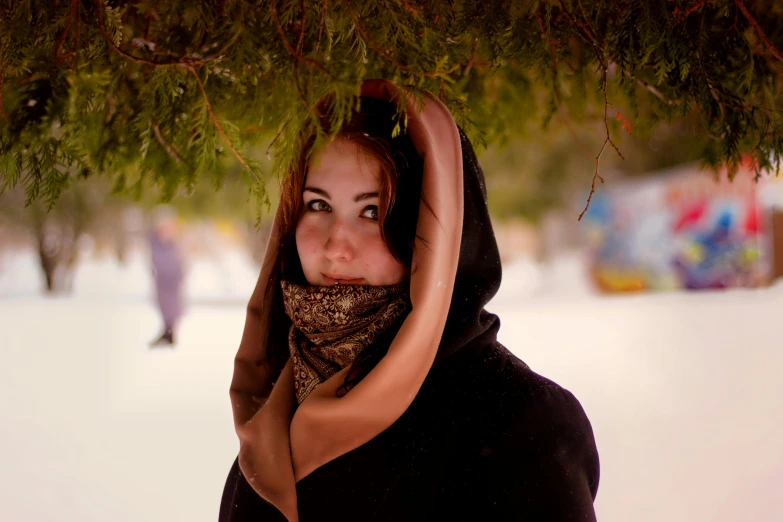 a woman standing underneath a tree with her hands around her face