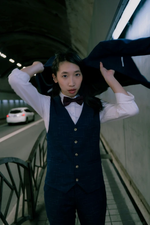 a young asian woman is wearing a vest and bow tie