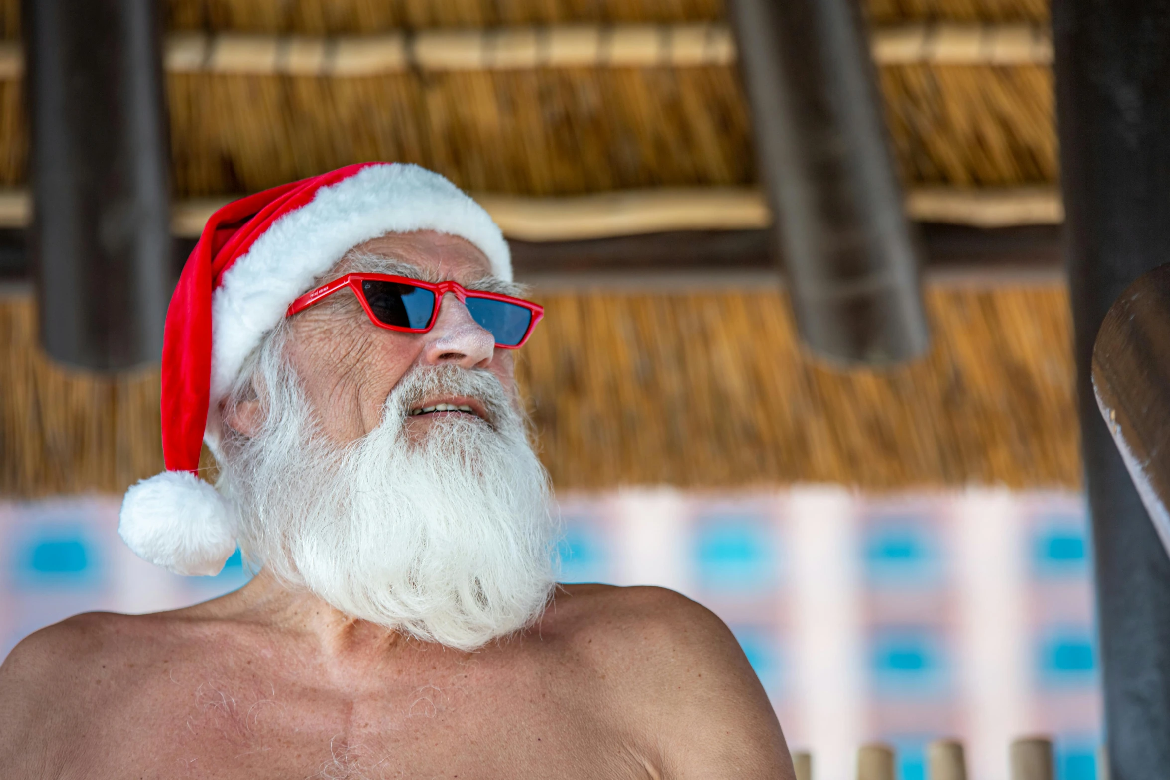 a shirtless man with a christmas hat and sunglasses on