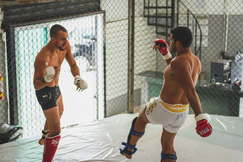 two boxers fighting in an indoor boxing ring