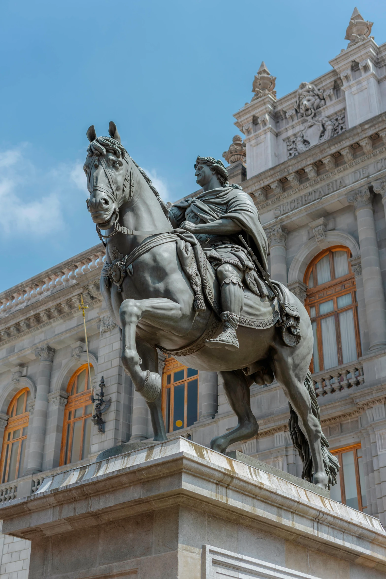 the statue of a man riding a horse outside a building