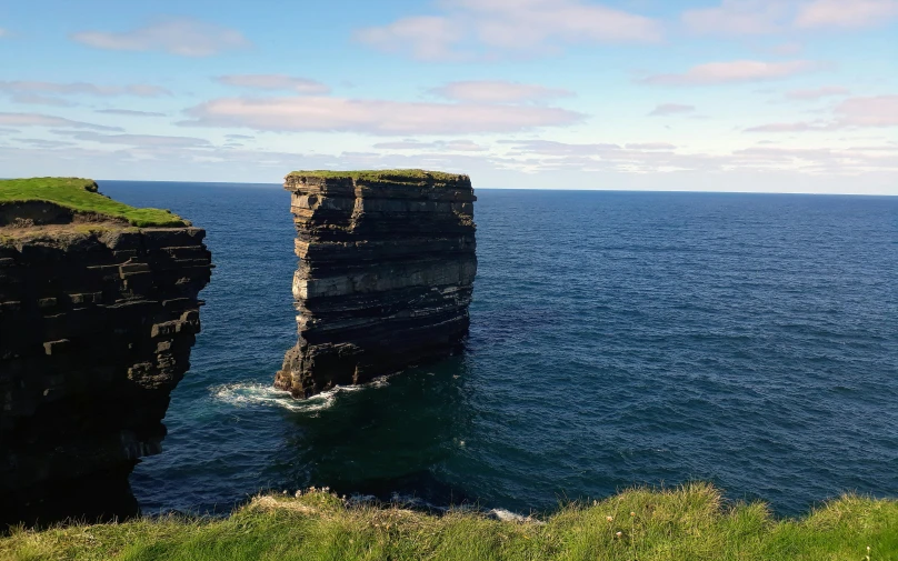 a cliff sits high above the ocean