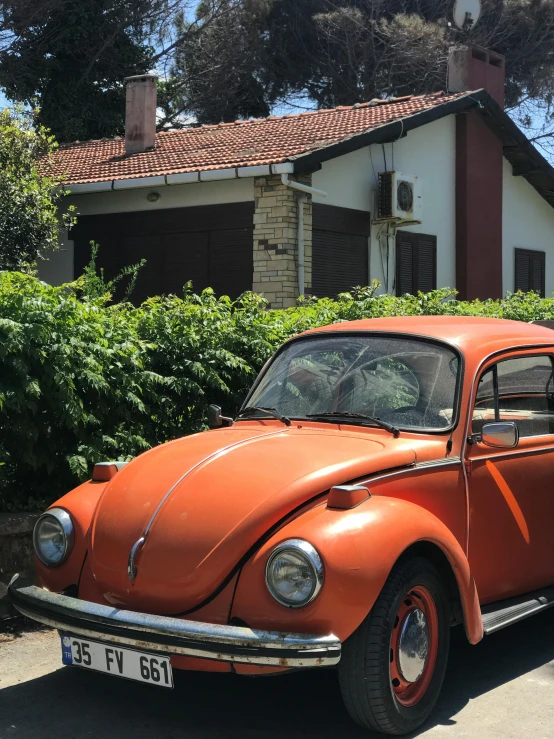 an old rusty beetle parked in front of a house