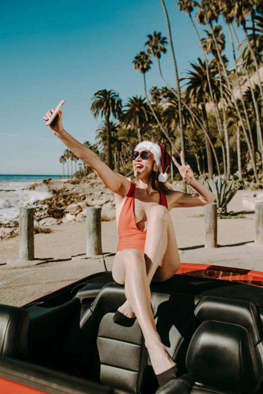 woman sitting in the back seat of a car with a santa hat and sunglasses on