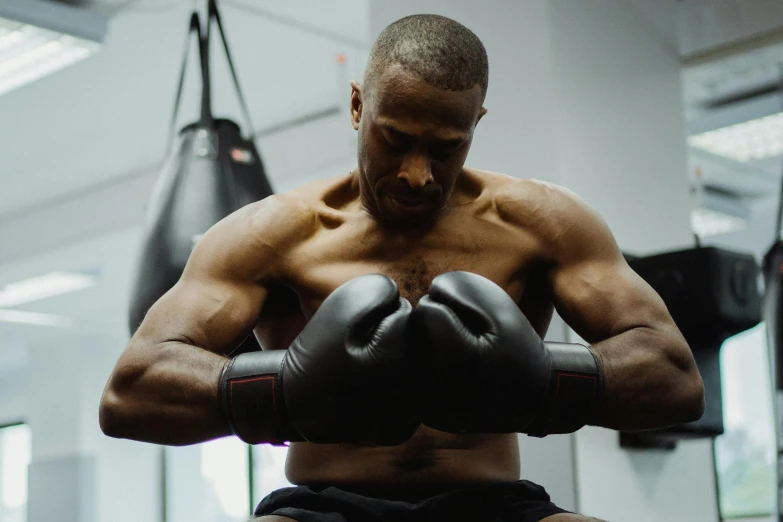 a man holding a punching glove in a gym