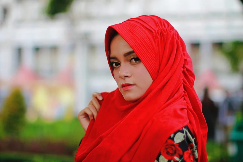 a beautiful young woman in a red head covering