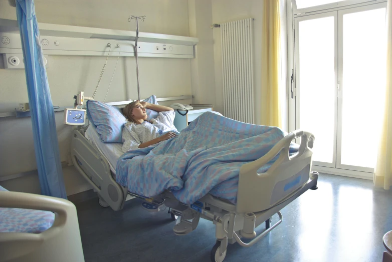 a woman laying in a hospital bed with an iv and a drip sprinkle attached