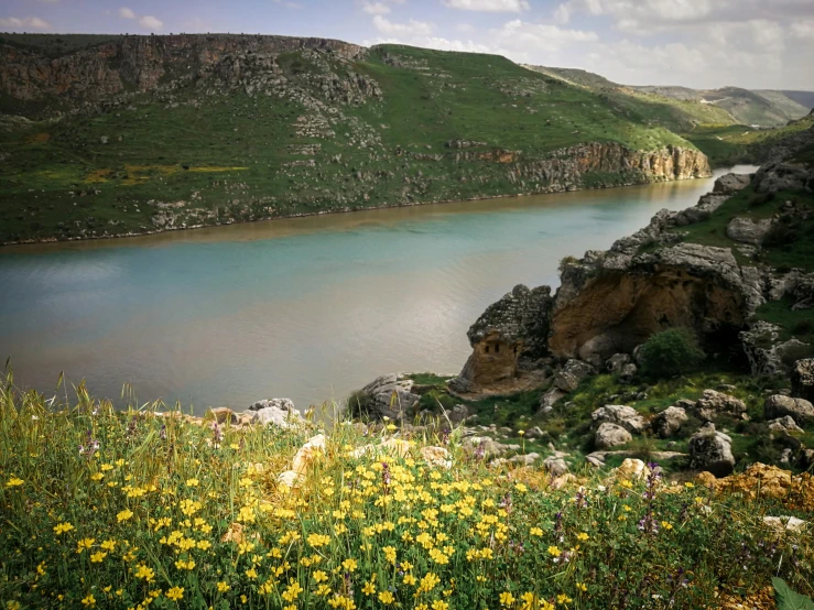 a lake is next to a large rock cliff