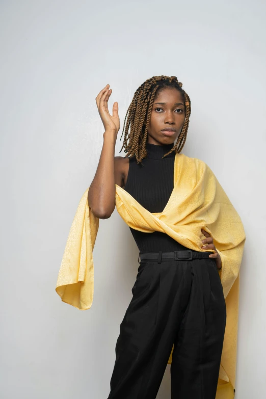 a young black woman posing for a picture in front of a white wall