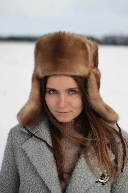 a woman with long red hair wearing a winter coat