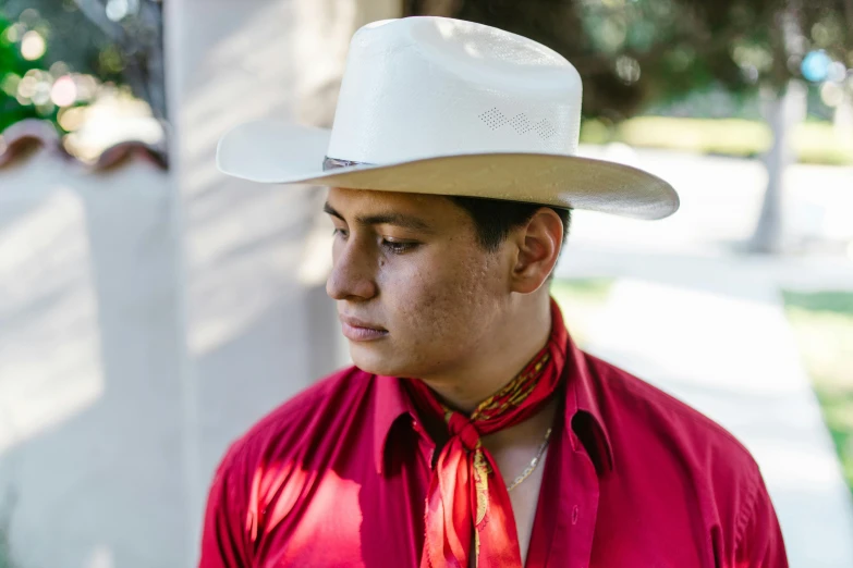 a man wearing a hat and tie looking back