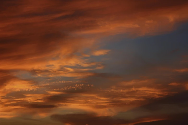 sunset clouds with trees silhouetted in the background