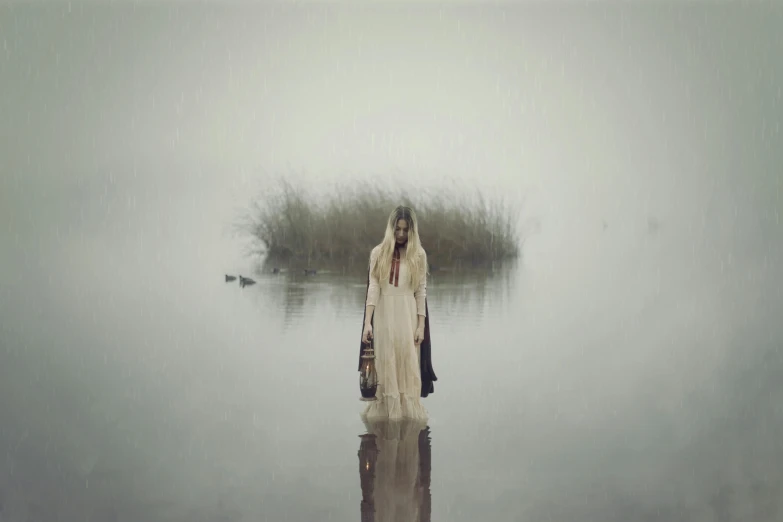 a woman standing in the water near a lake