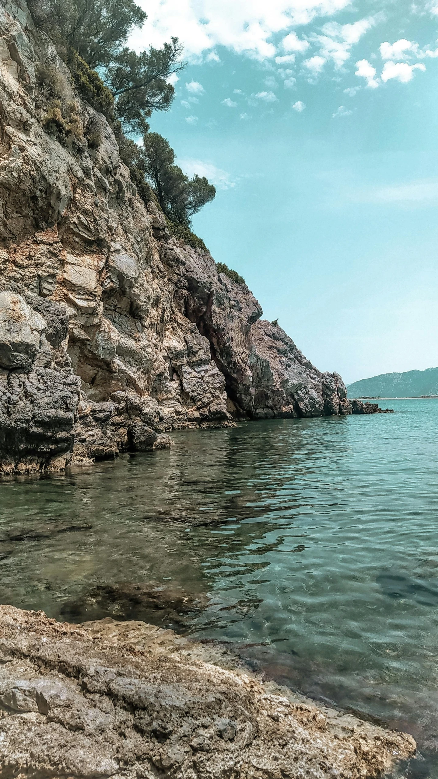 there is an empty rocky beach with clear blue water