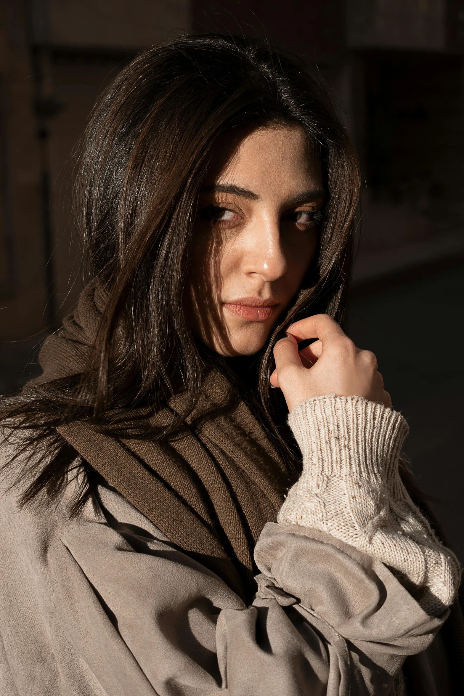 a woman wearing a gray sweater and holding a cell phone