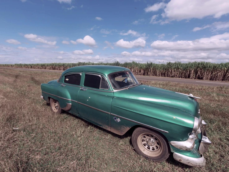 the old car is sitting out in the field