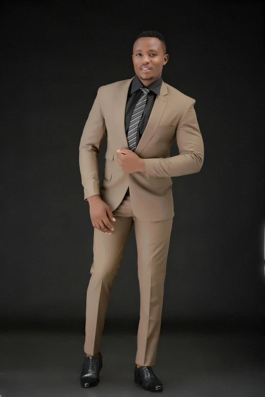a man dressed in a tan suit posing for a picture