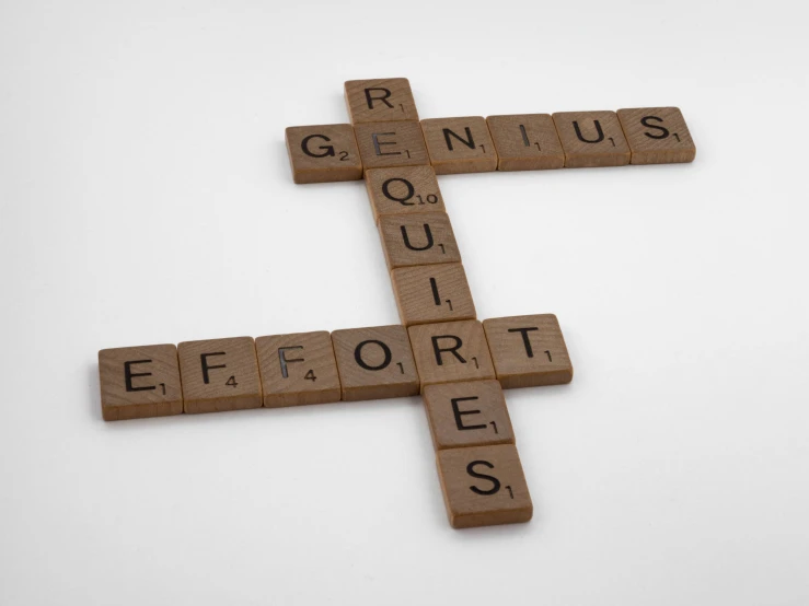 a cross made of scrabble letters that spell out genius
