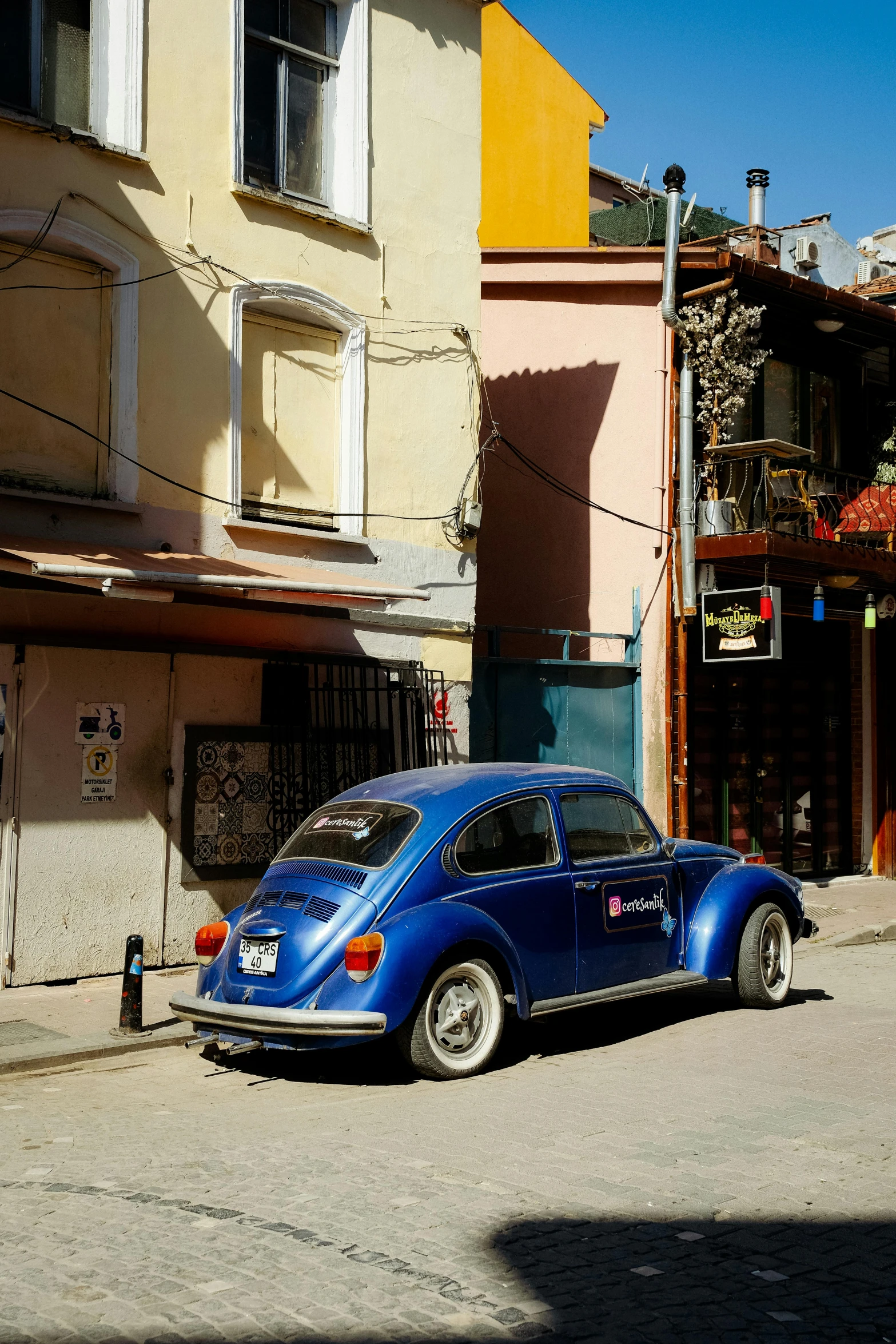 a small blue car is parked on the street