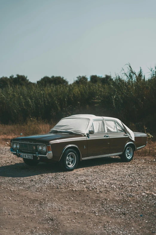 a black station wagon sitting in the middle of a field