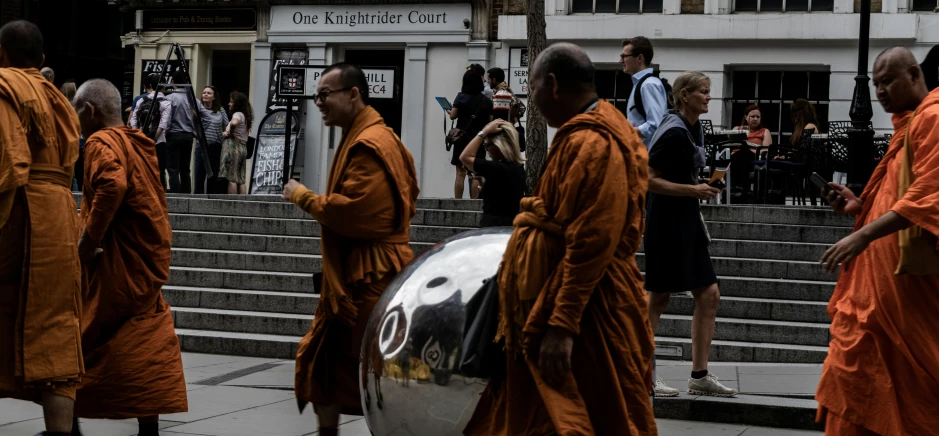 several monks in robes are walking down a set of steps