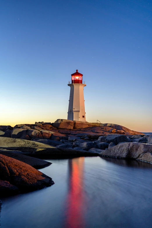 the light house is located at night, over looking the ocean