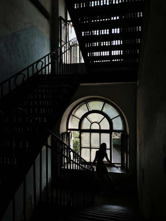 a man sitting on stairs looking out an open window