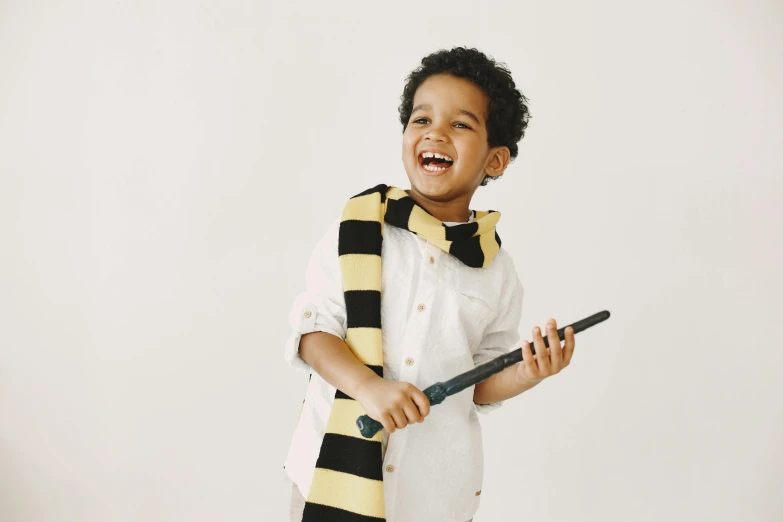 a boy with a  scarf holding a black and yellow baseball bat