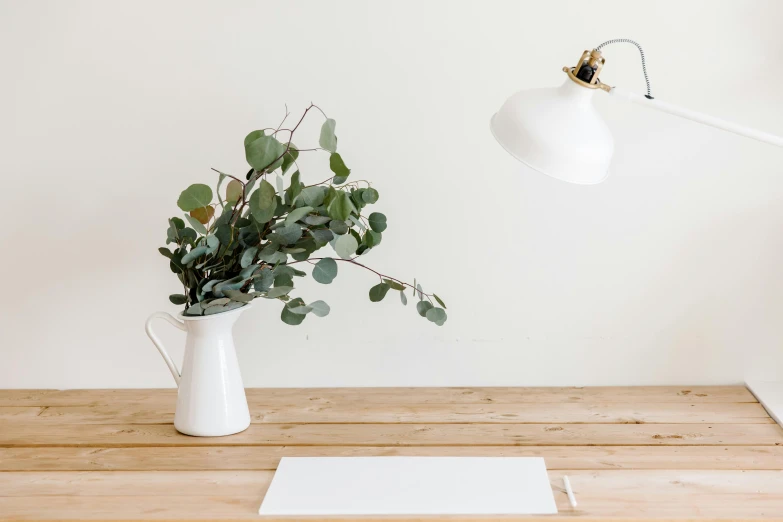 there is a white flower pot on the table