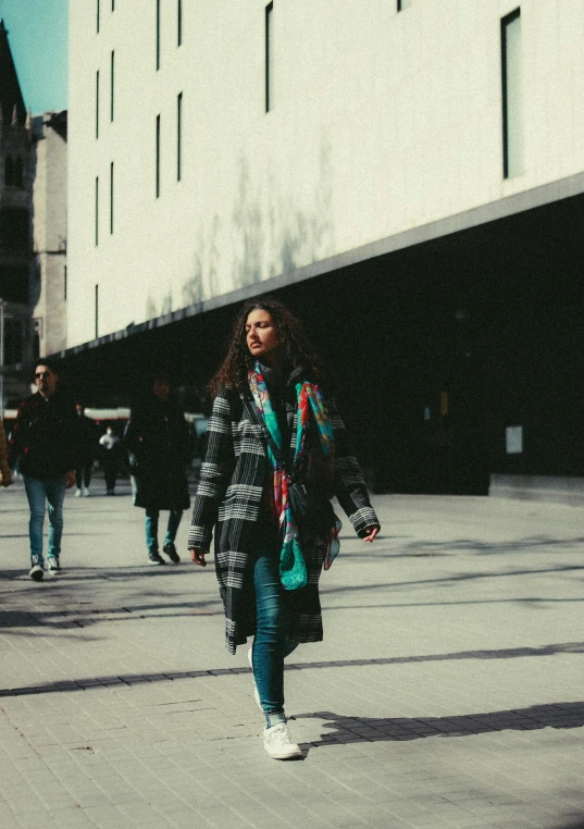 a woman walking down a street carrying a purse