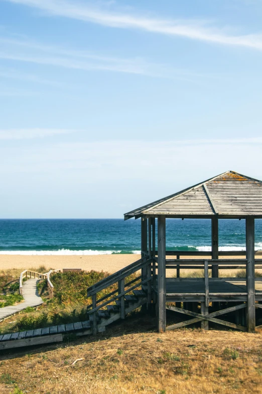 a gazebo in the sand at an empty beach