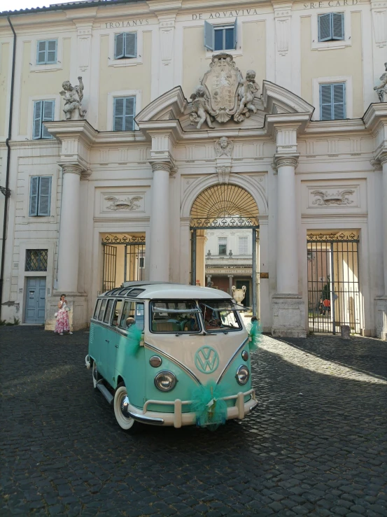 the vw bus is parked in front of an old white building