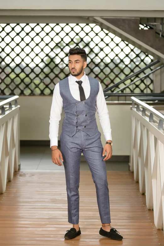 a man in blue suit standing on wooden floor