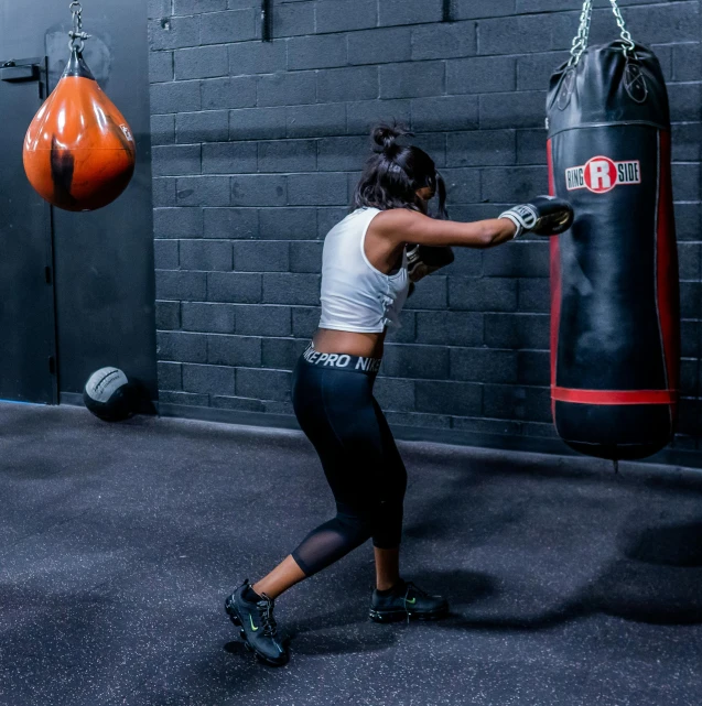 a woman doing a kick boxing with her punching glove