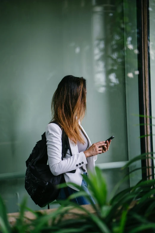 a girl looking at her cell phone while waiting