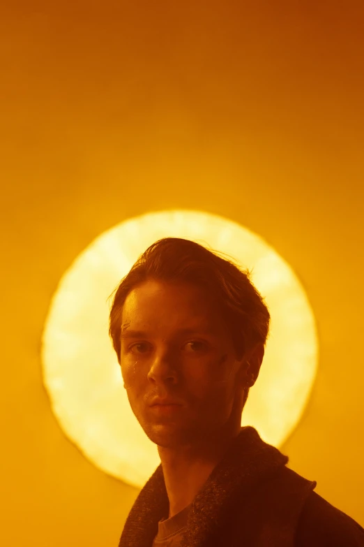 man in dark clothing with yellow circular light