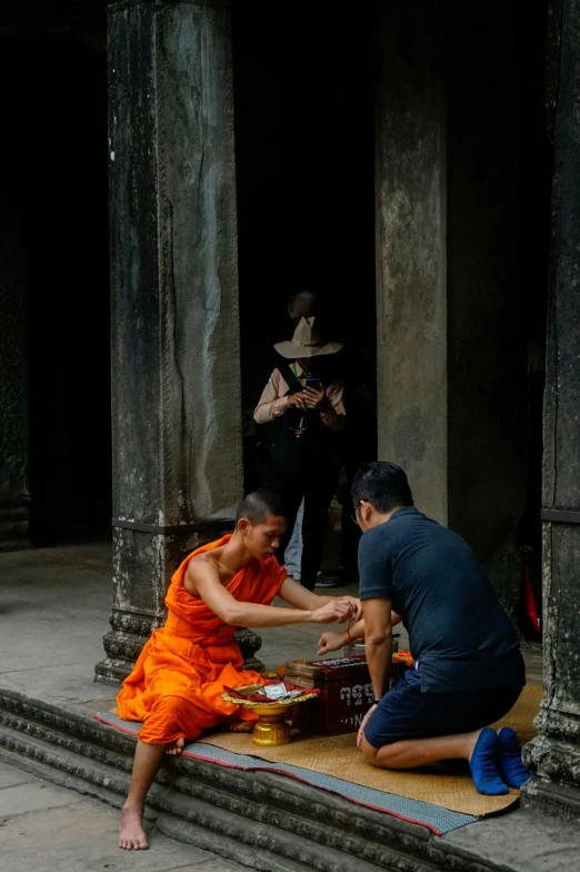 two monks are outside on the steps to pray