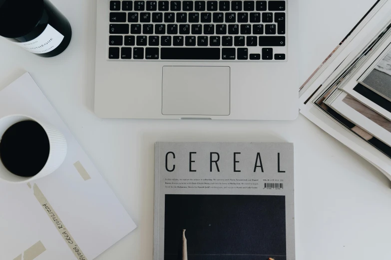 the laptop has a book about cereal next to it